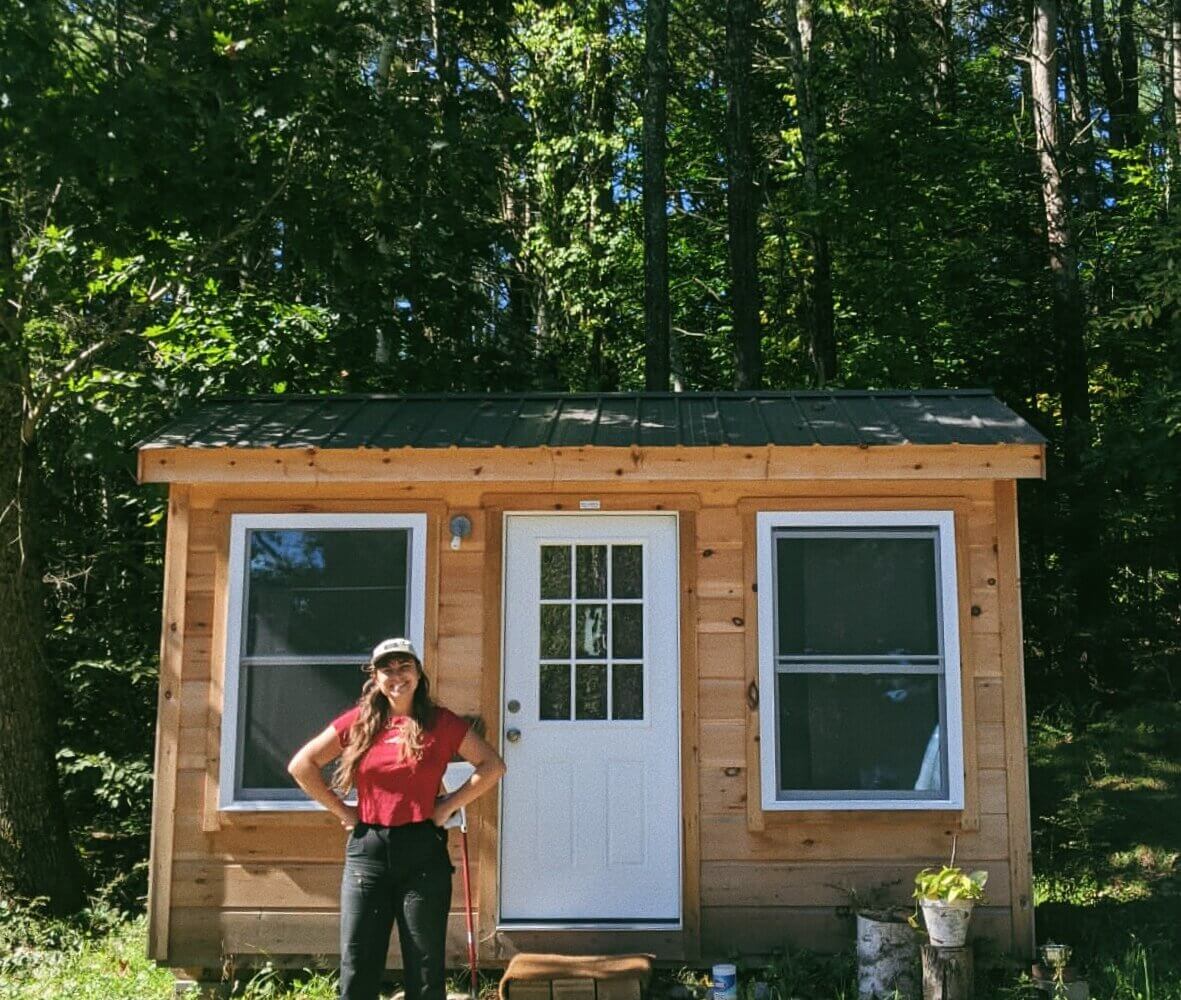 A cabin with a person standing in front